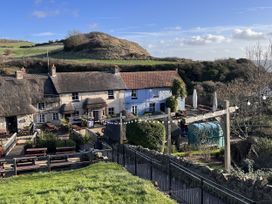 An outdoor area with cottages, seating, and a hill at Agua de Plata, 16 Wakeling Island, Silverlake, Dorchester