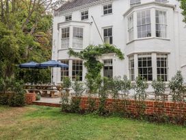 An outdoor area with a table and umbrellas at Syleham House in Syleham near Eye