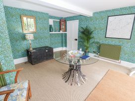 A sitting room with a glass table and plant at Syleham House Syleham near Eye