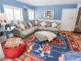 A living room with a sofa and bookshelf at Syleham House in Syleham near Eye