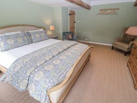 A bedroom with a bed and armchair at Syleham House Syleham near Eye