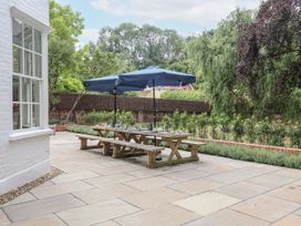 A garden with a table and benches under an umbrella at Syleham House Syleham near Eye