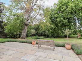 A garden with a bench and trees at Syleham House in Syleham near Eye
