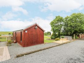 A cabin with a hot tub and deck in the outdoor area at Mallard Lodge in Moscow near Galston