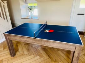 A ping pong table with paddles and a ball at Rhos Las in Cerrigydrudion