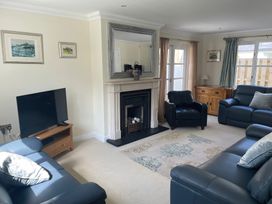 A living room with a fireplace and television at 3 Strawberry Close Little Haven near Broad Haven