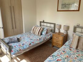 A bedroom with two beds and a bedside table at 3 Strawberry Close Little Haven near Broad Haven