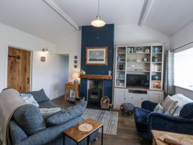A living room with a fireplace and a bookshelf at Bwthyn Y Swnt in Moelfre
