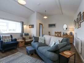 A living room with a sofa and armchair at Bwthyn Y Swnt in Moelfre