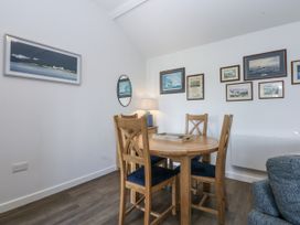 A dining room with a table and chairs at Bwthyn Y Swnt in Moelfre