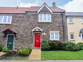 A house with a red front door and green bushes at The Beach Retreat The Bay - Filey