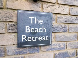 A sign reading The Beach Retreat on a brick wall at The Beach Retreat The Bay - Filey