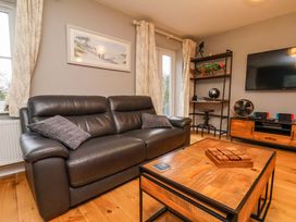 A living room with a sofa, table, and television at The Beach Retreat The Bay - Filey