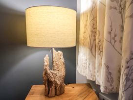 A lamp with a wooden base on a table in the living room at The Beach Retreat The Bay - Filey