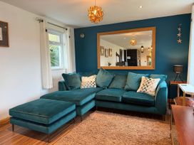 A living room with a sofa and a mirror at Pasadena in Newquay