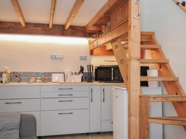 A kitchen with appliances and a staircase at Little Coombe Trehunist near Liskeard