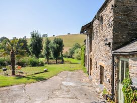 An outdoor area with a palm tree and furniture at Little Coombe Trehunist near Liskeard