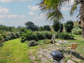 A garden with a table and chairs at Little Coombe in Trehunist near Liskeard