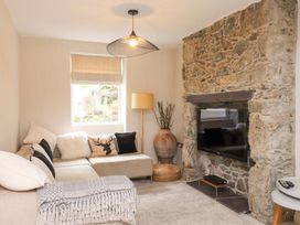 A living room with a sofa, television, and lamp at Hendre in Menai Bridge