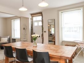 A dining room with a wooden table and chairs at Hendre in Menai Bridge