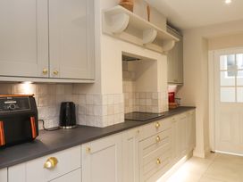 A kitchen with cabinets, appliances, and a door at Hendre in Menai Bridge