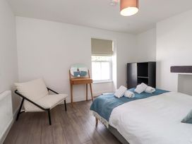 A bedroom with a bed and chair at Hendre in Menai Bridge