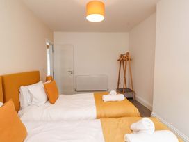 A bedroom with two beds and a coat rack at Hendre in Menai Bridge