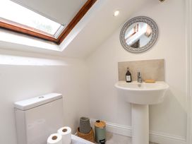A bathroom with a sink and toilet with a mirror at Hendre in Menai Bridge