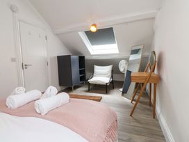 A bedroom with towels on a bed and a chair at Hendre in Menai Bridge
