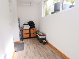 A utility room with storage bins and folded towels at Hendre in Menai Bridge