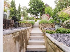 A garden with steps leading up and a sculpture at Hendre in Menai Bridge