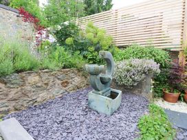 A garden with a fountain and various plants at Hendre in Menai Bridge
