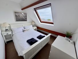 A bedroom with a bed and side tables at 220 Cae Du in Abersoch