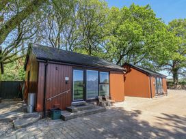 A cabin with patio area and chairs at Jasmine in Bydown near Barnstaple