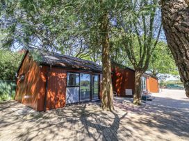 A cabin with trees and a pathway at Fern in Bydown near Barnstaple