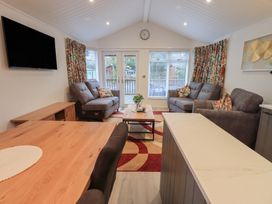 A living room with a television and sofas at Merewood in Troutbeck Bridge