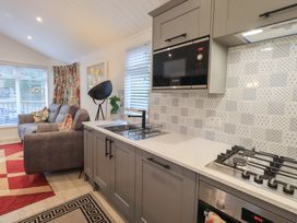 A kitchen with a sofa and microwaves at Merewood in Troutbeck Bridge