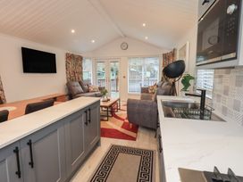 A living room with a television and dining table at Merewood in Troutbeck Bridge