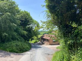 A view of a road winding down to a house surrounded by greenery at Church Farm Dairy Cadbury near Thorverton