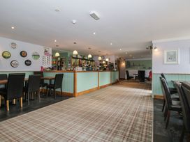 A restaurant with a bar counter and seating at Swan in Shobdon