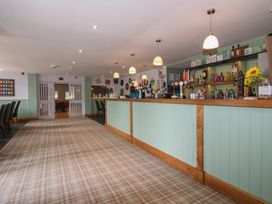 A bar area with stools and a counter at Swan in Shobdon