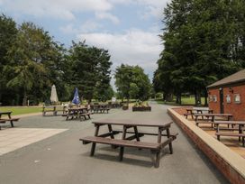 An outdoor area with tables and umbrellas at Swan in Shobdon