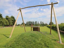 A playground with swings and a sandy area at Swan in Shobdon