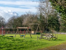 A playground with swings and climbing frame at Heron in Shobdon