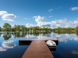 A dock with a boat on a lake at Heron in Shobdon