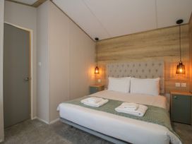 A bedroom with a double bed between two bedside tables and hanging lamps at Owl in Shobdon