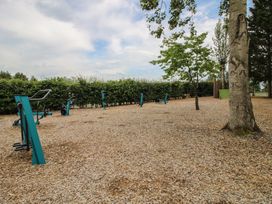 An outdoor exercise area with equipment and trees at Owl in Shobdon