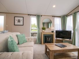 A living room with a sofa and television at Owl in Shobdon
