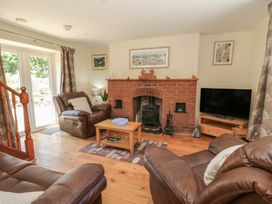 A living room with a fireplace and sofa at Felin Gogoyan Tregaron