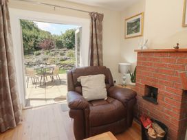 A living room with a chair and a fireplace at Felin Gogoyan in Tregaron